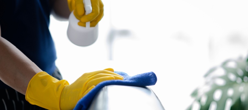 Gloved hand disinfecting a salon counter during commercial cleaning in Coral Springs