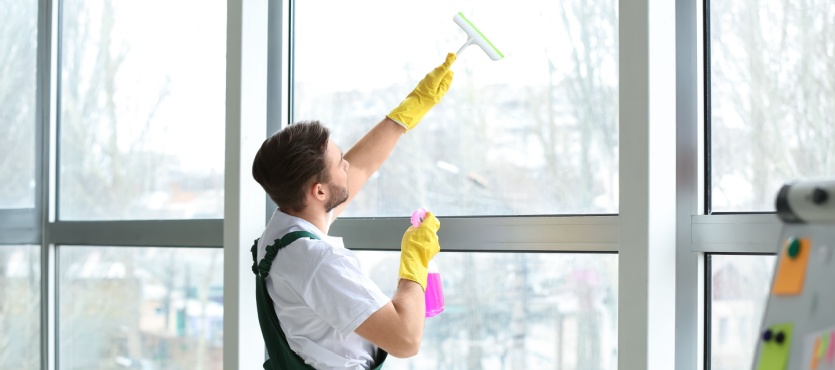 Man cleaning tall office windows during commercial window cleaning in Delray Beach