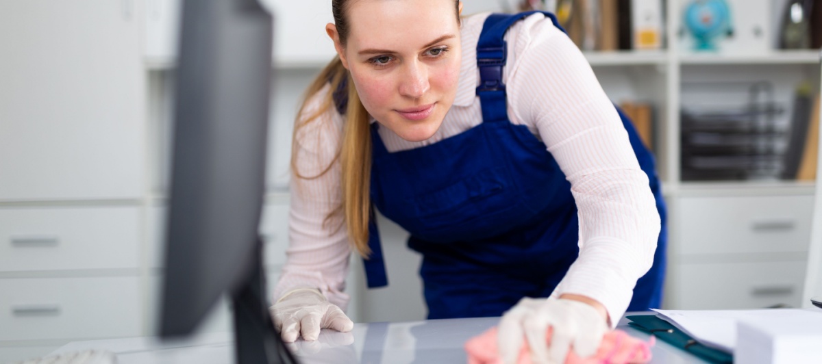 Cleaner wiping a desk for an office cleaning company in Davie