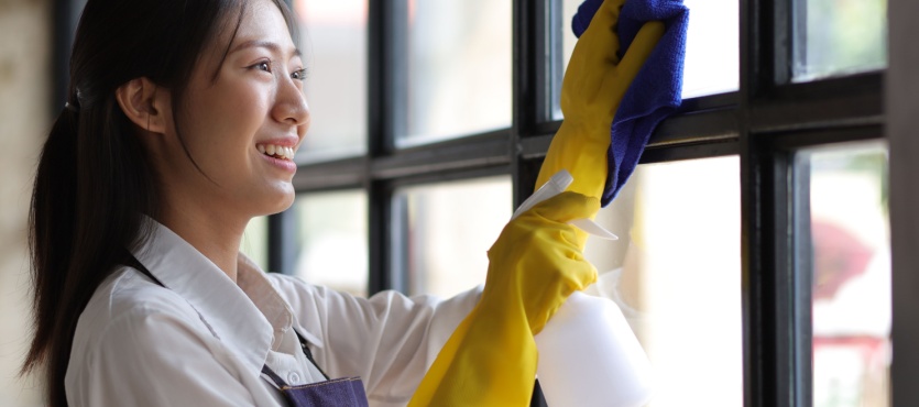 Cleaner wiping office windows during commercial window cleaning in Delray Beach