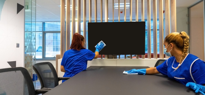 Two cleaners wiping a conference room for an office cleaning company in Fort Lauderdale