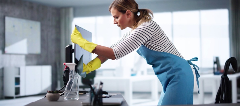 Cleaner wiping office furniture for an office cleaning company in Plantation
