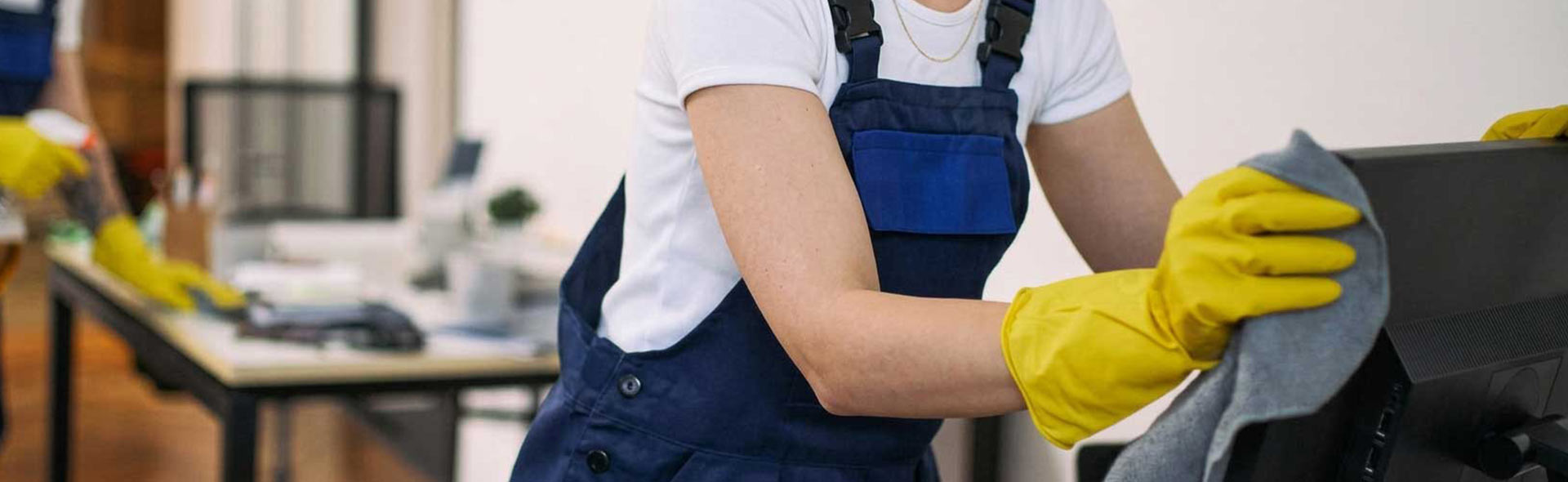 Cleaner wiping an office desk during janitorial services in Pompano Beach