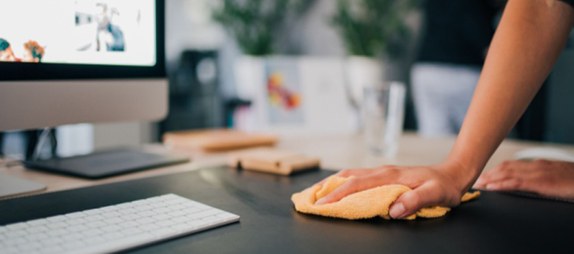 Wiping an office desk for an office cleaning company in Pompano Beach