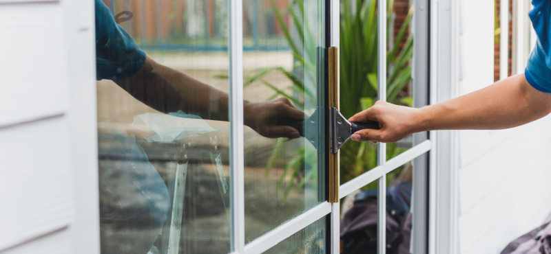 Cleaning a glass door handle, an often overlooked spot in commercial cleaning in Delray Beach