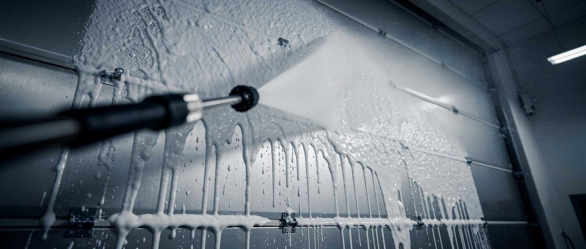 Pressure washing a building wall during commercial pressure cleaning in Delray Beach