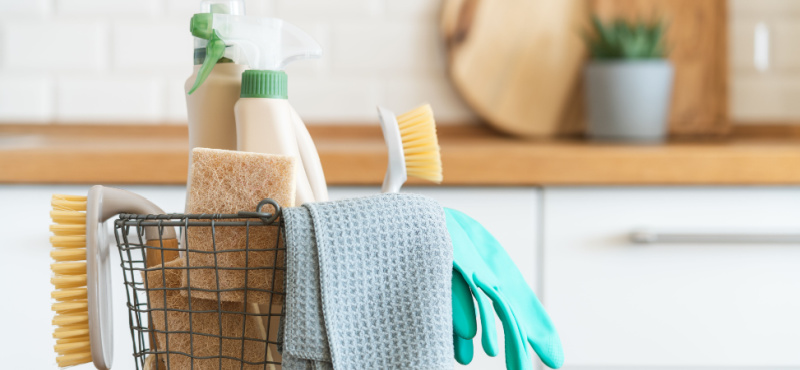 Basket of cleaning supplies on a kitchen counter for janitorial services in Davie