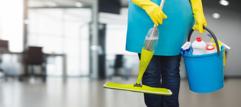 Cleaner carrying a mop and bucket for janitorial services in Davie