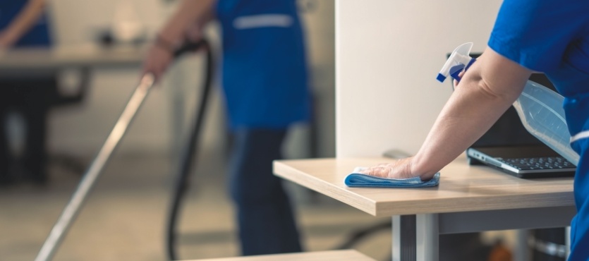 Wiping down a desk to disinfect an office during commercial cleaning in Fort Lauderdale