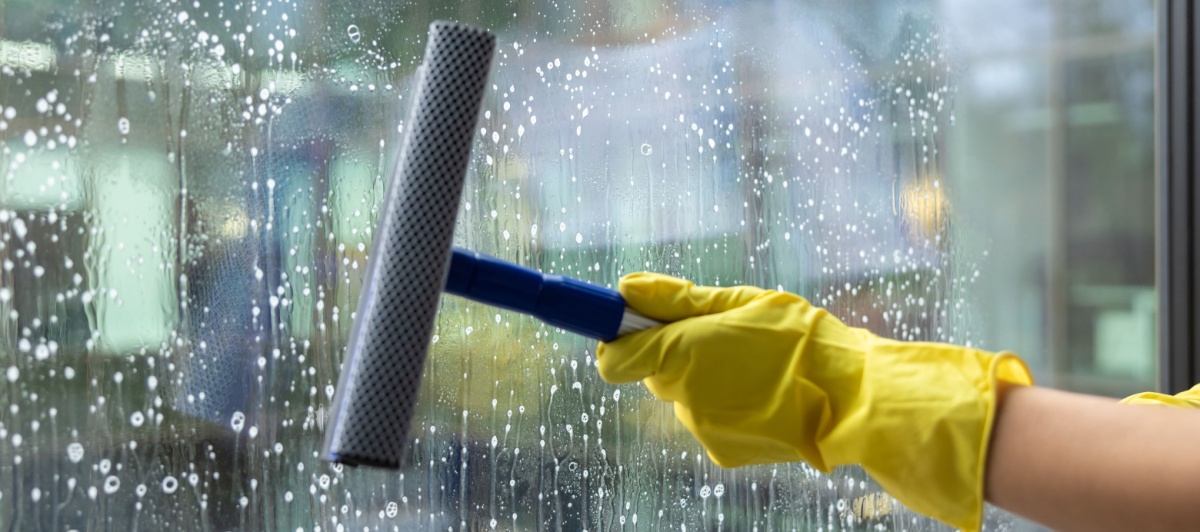Squeegee removing hard water spots during commercial window cleaning in Plantation