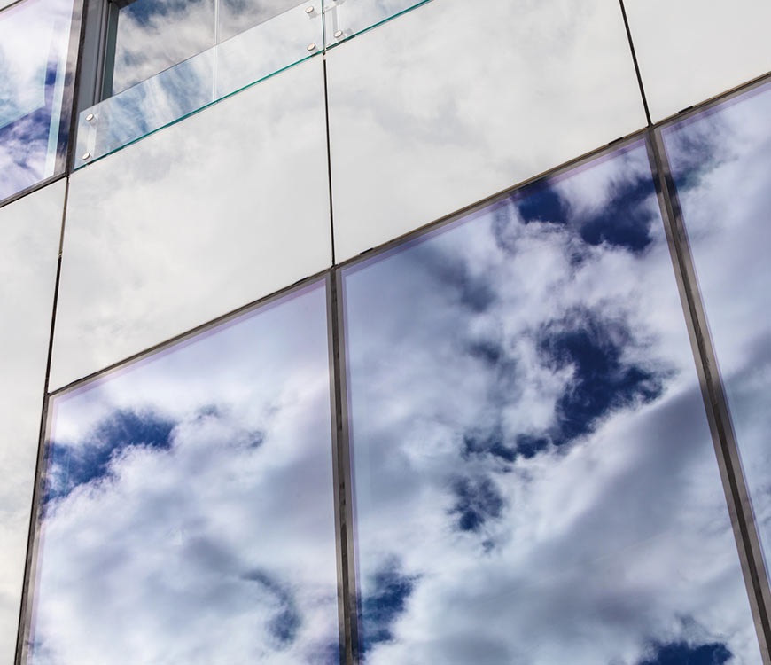 Clean glass windows reflecting clouds after commercial window cleaning in Coral Springs